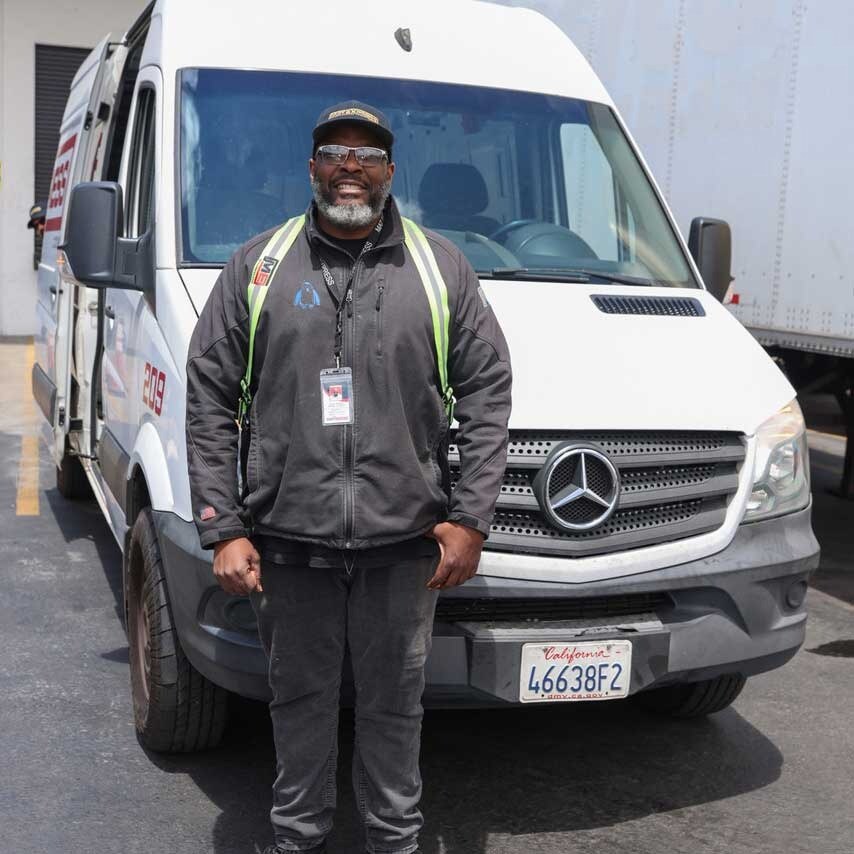 Man Standing In Front Of Company Van